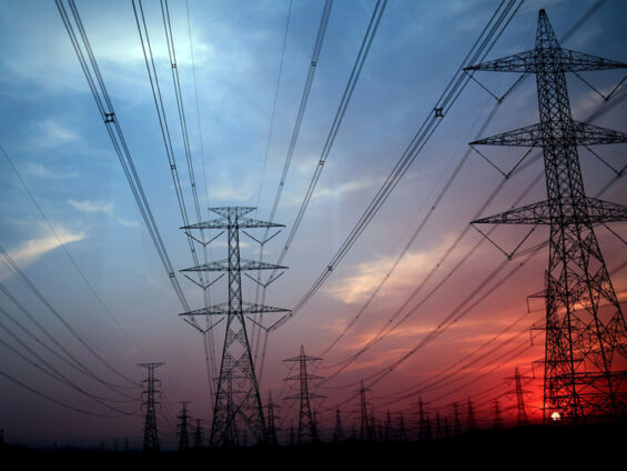 Pylônes électriques haute tension au soleil couchant.
