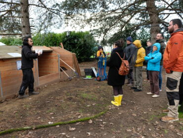 le maître composteur explique le fonctionnement du composteur à la petite ferme urbaine.