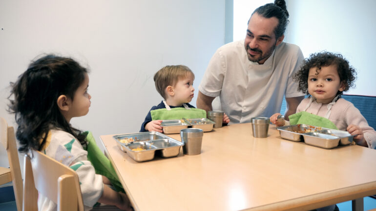 Le cuisinier de la crèche Pomme de reinette vient voir les enfants pour savoir si le repas se déroule bien.