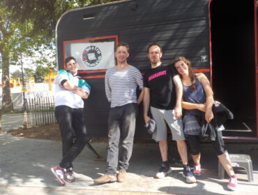 Les membres de la compagnie du théâtre clandestin devant la caravane qui leur sert de scène de théâtre.