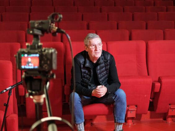 Alain Ughetto assis sur les sièges de la salle de cinéma du Lutétia.
