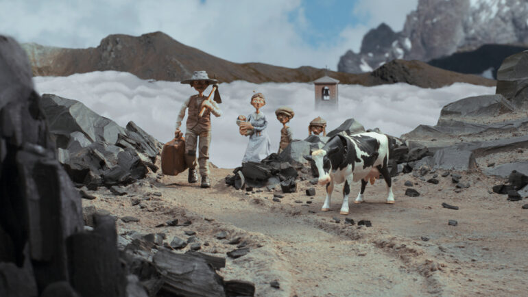 Luigi, Cesaria et leurs trois enfants se émergent face caméra depuis un chemin de montagne caillouteux. En arrière plan, le clocher d'une église perce la brume dans la vallée.