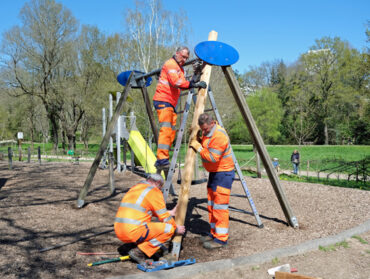 Trois agents du groupe d'intervention rapide changent le montant d'un balançoire au parc de la Chézine.