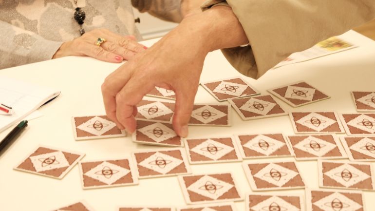 On peut voir en gros plans la main d'un senior entrain de jouer au carte.