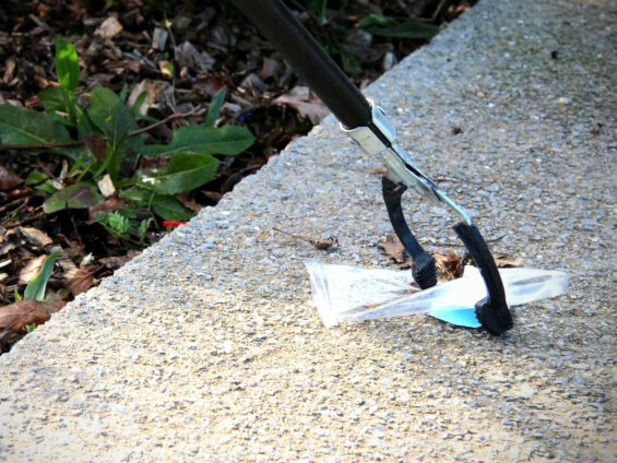Ramassage de déchets jetés au sol grâce à une pince télescopique