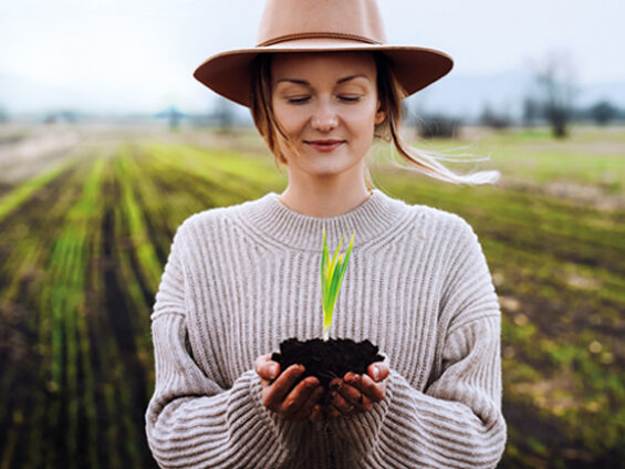 Une femme tient entre ses mains une graine en train de pousser.