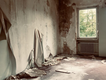 intérieur d'une pièce rongée par l'humidité avec le papier peint et le revêtement du mur qui se décolle.