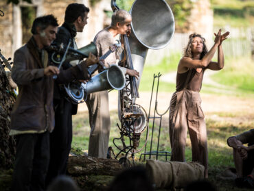 Les artistes de la Fausse Compagnie jouent de drôles d’instruments dans un parc.