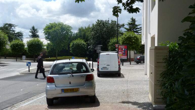 Des voitures sur un trottoir dont le stationnement est gênant.