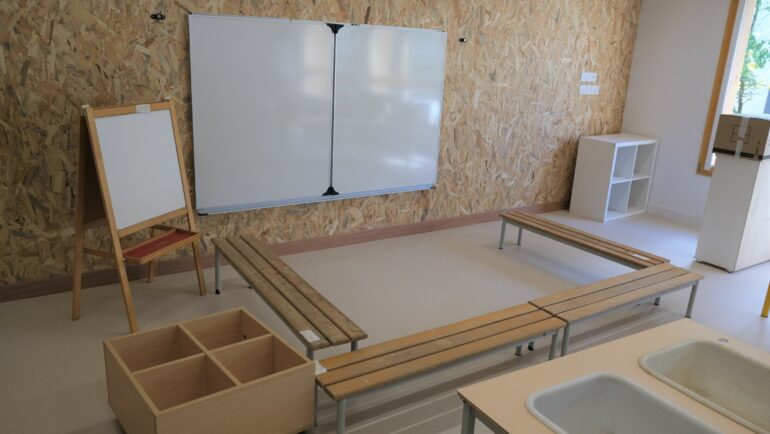 Une salle de classe de l'extension de l'école Condorcet. On y voit un tableau blanc, des bancs et quelques rangements.
