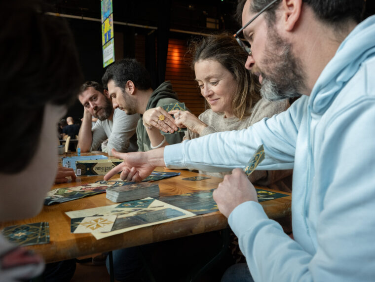 Plusieurs personnes autour d'une table jouent lors du Festival des Jeux.