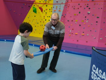 Exercice de coopération, lors d'une séance de sport, qui réunit un garçon de 4 ans et un personne âgée.