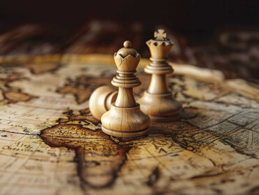 Des pions d'échec sont positionnés sur une vieille carte du monde.